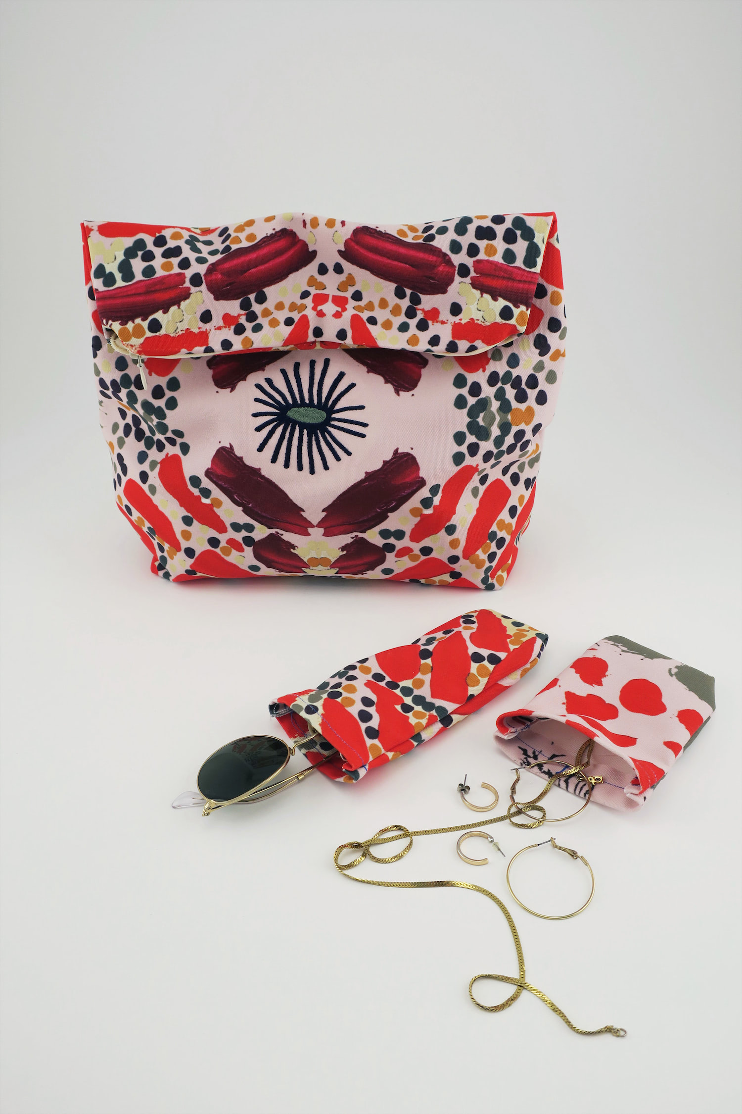 Studio shot of jewelry bags in use with sunglasses, necklaces, and earrings.