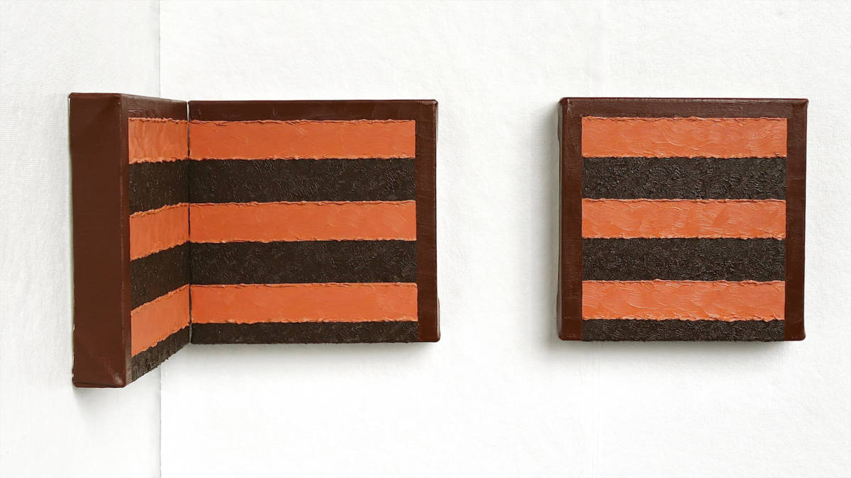 An impasto triptych of a chocolate cake that is installed in the corner