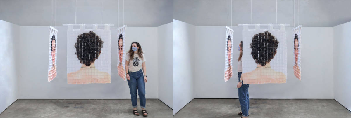 Two images are shown, both showing four quilts hanging in a stark white room, forming a cell-like space. An image of the back of the artist's head, distorted by a grid, faces outward on one quilt, and is perpendicularly flanked by quilts on either side which feature the artist's face, also distorted by the grid. In the photo on the left, a woman with curly brown hair is outside the cell-like structure, on the right, looking in. In the photo on the left, the same woman stands inside the structure, staring at the artist's distorted face.