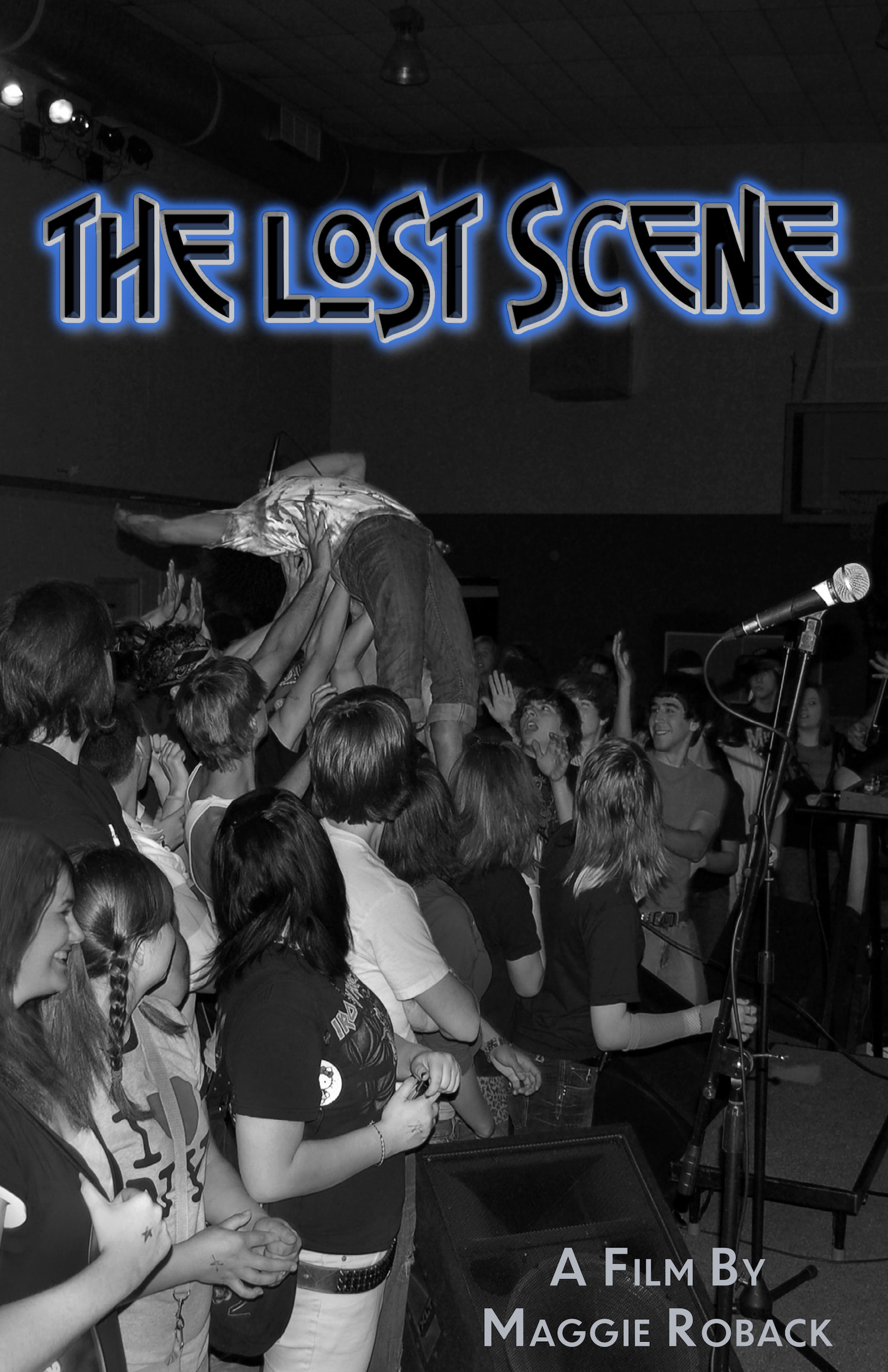 Text - The Lost Scene, A Film By Maggie RobackImage - A high school aged male dives off a small stage, backwards, into a crowd. Many arms reach up from the crowd to hold him up.