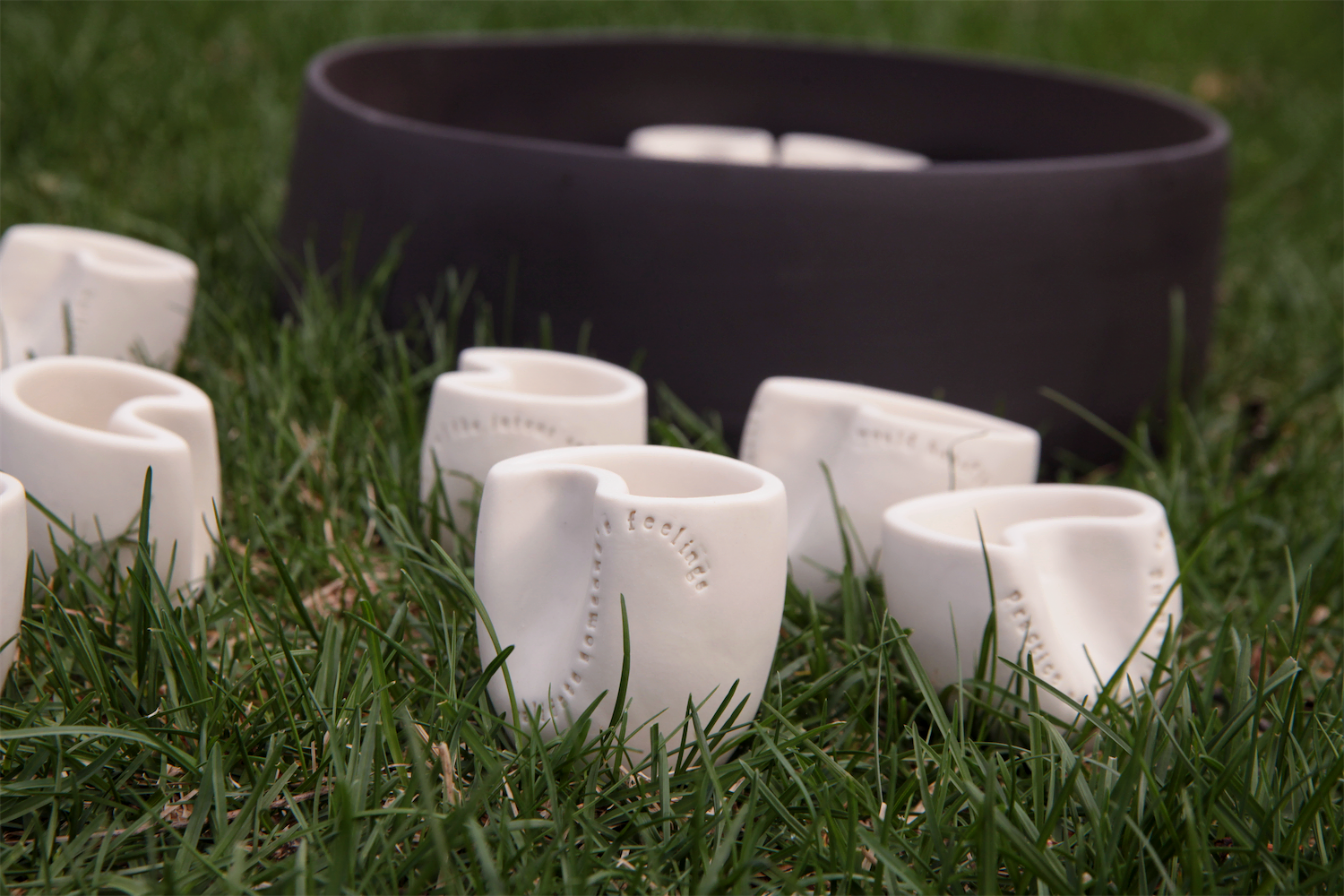 Several cups scattered outside of the carrier in the grass.  The carrier is in the background.