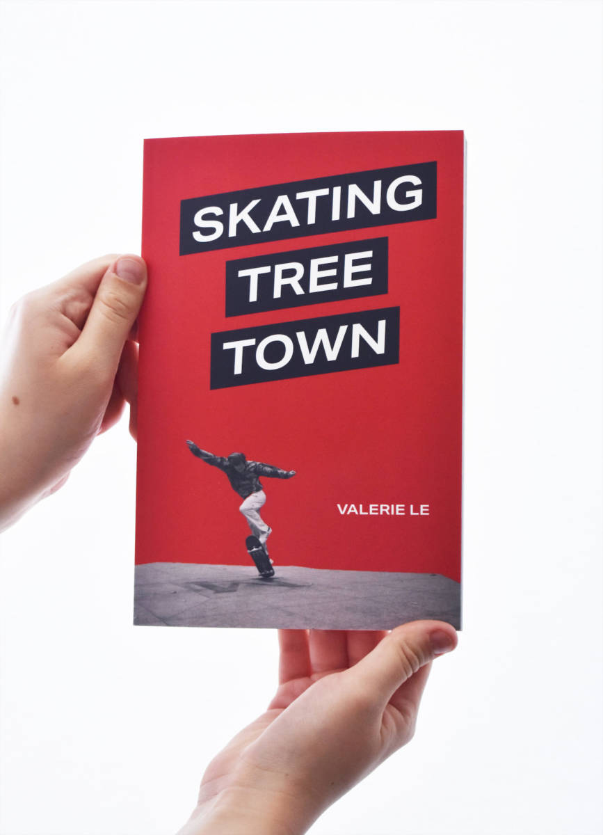 Hands holding up the Skating Tree Town book.
