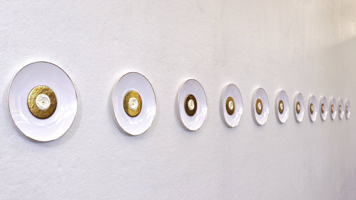Installations of creamy and glossy white-and-gold circles