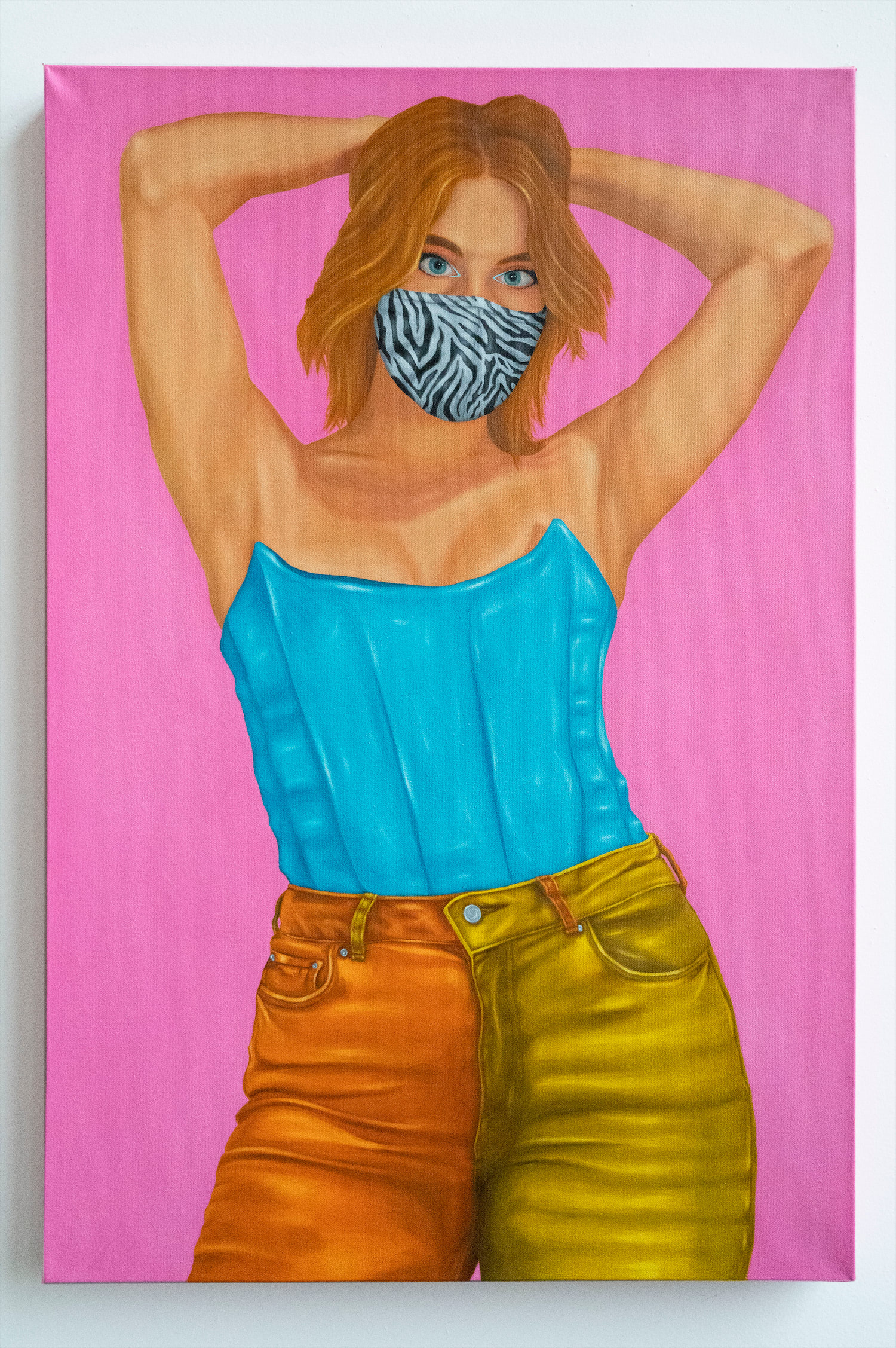Sophie wearing a sky blue latex corset and orange and yellow color blocked jeans, accessorized with a zebra patterned mask.