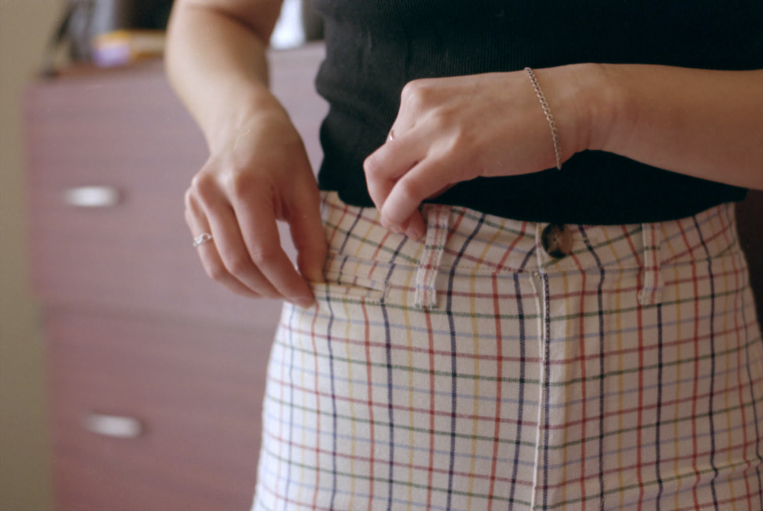 Image of Katie adjusting the pocket on her plaid pants