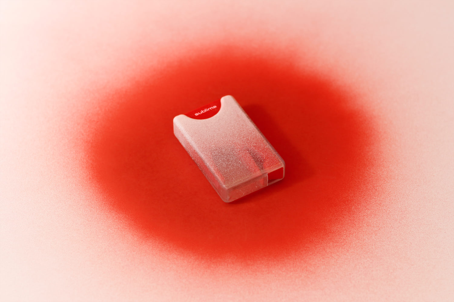 A photo showing the pill dispenser, at a distance, on a spray-painted red backdrop.