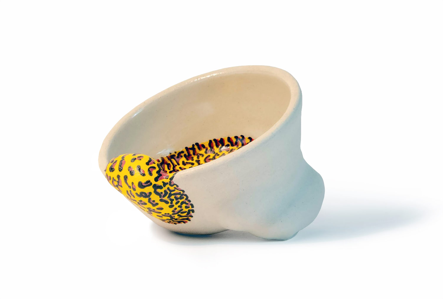 An image of a white bowl form with a yellow, red, and black line pattern that sculptural surface additions that move from the exterior to the interior.
